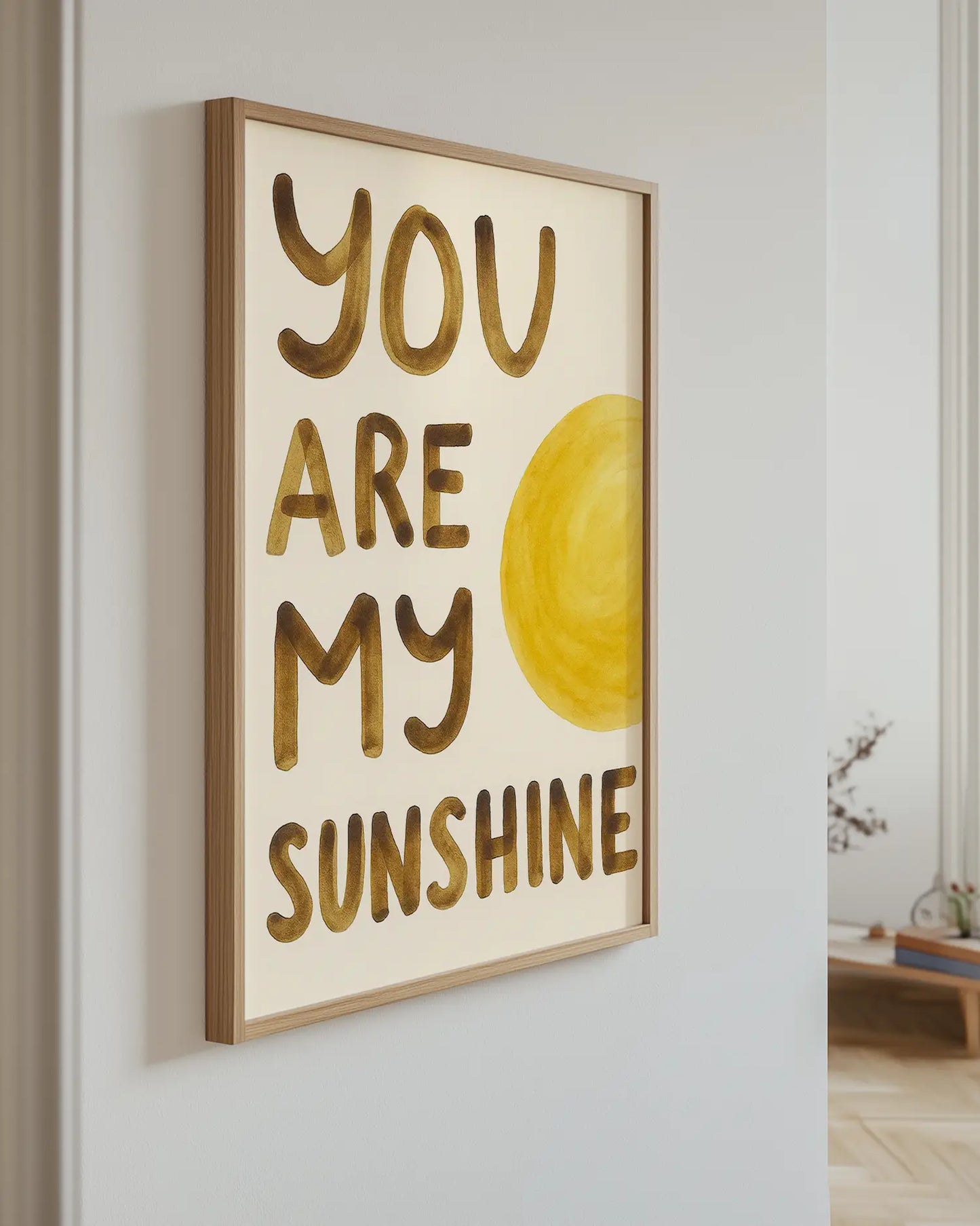 Framed artwork with 'You are my sunshine' text and a yellow sun on a light background.