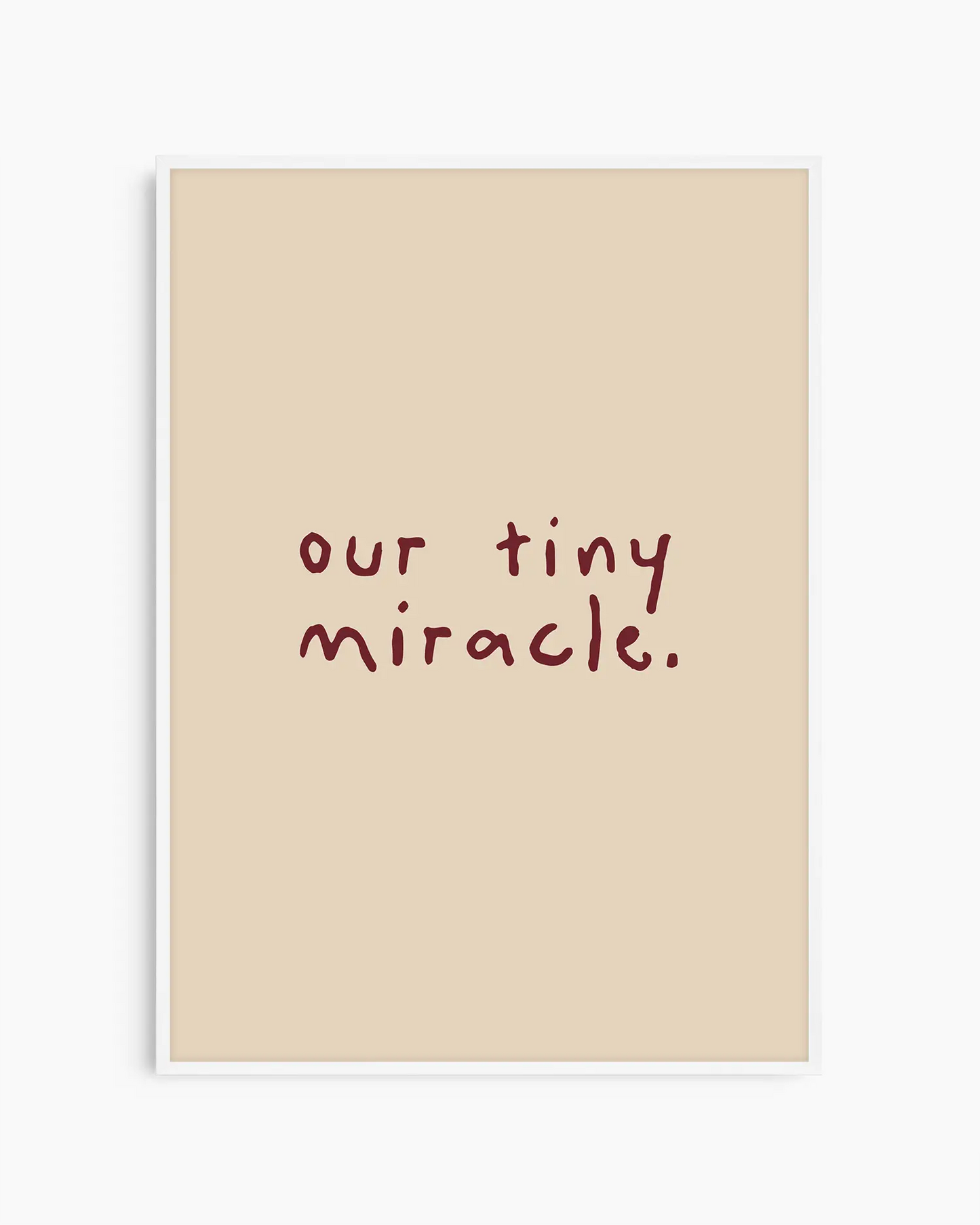 Beige nursery poster with 'our tiny miracle.' text in brown framed in a white frame.