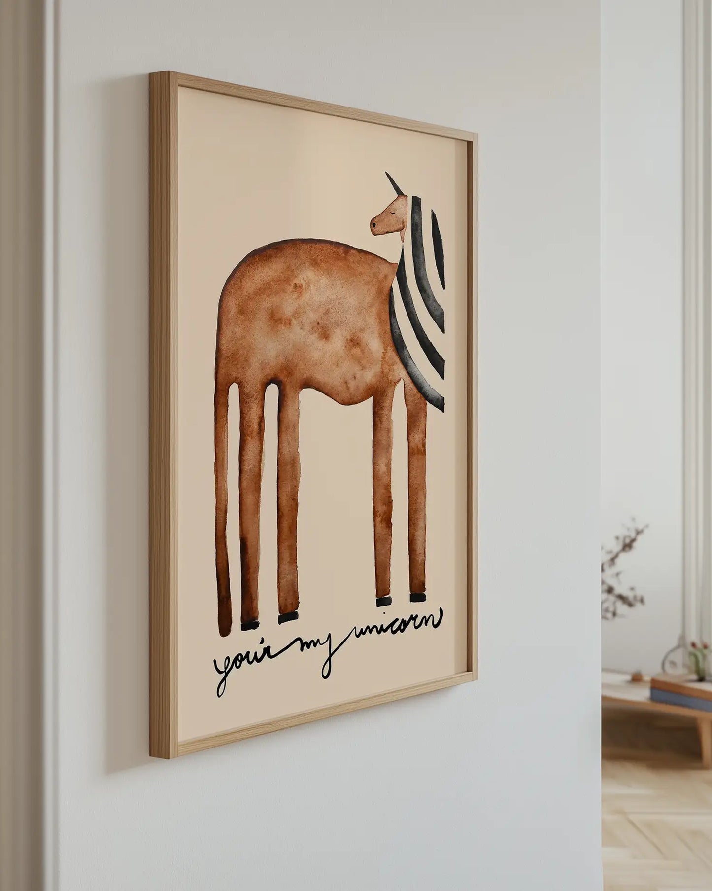 Framed artwork of a brown unicorn with long legs and the text "you're my unicorn" on a beige background