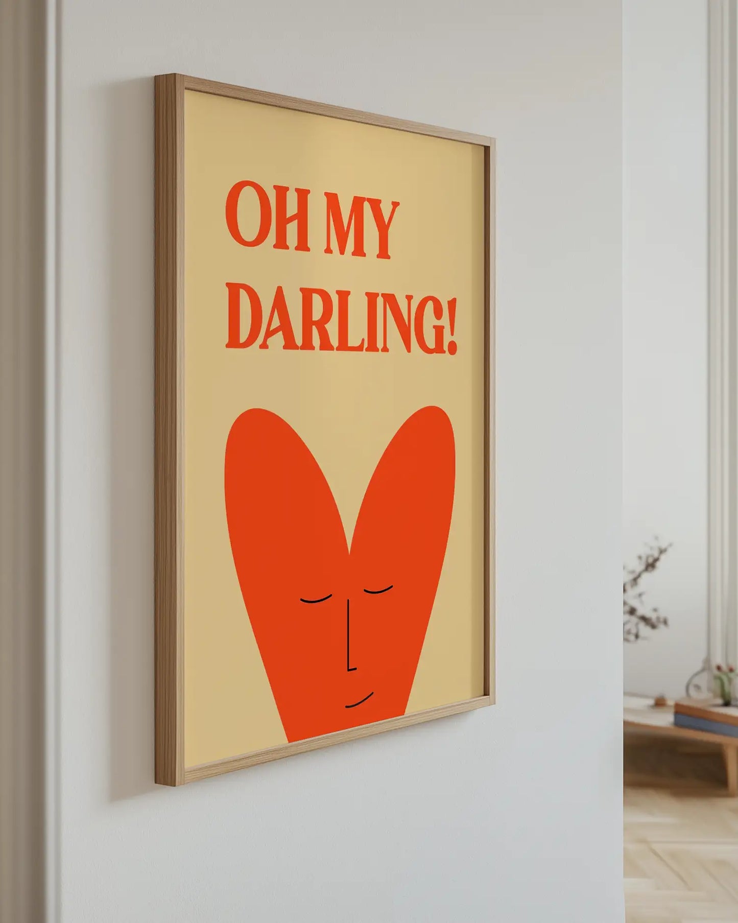 Framed artwork with 'OH MY DARLING!' text and a red heart on a beige background, hanging on a wall.
