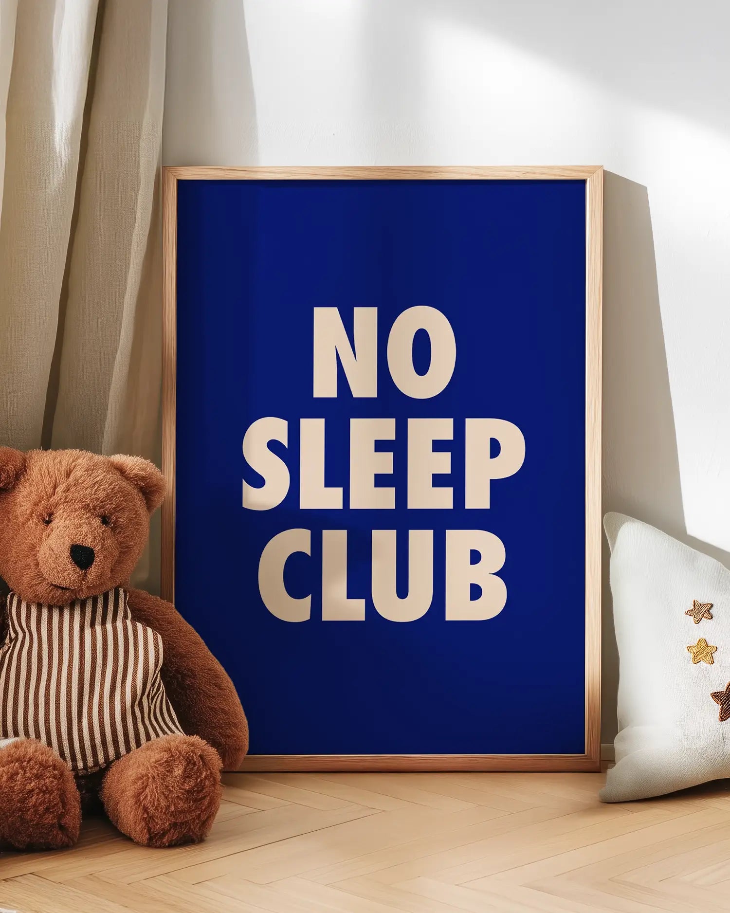 Poster with 'NO SLEEP CLUB' text next to a teddy bear on a wooden floor.