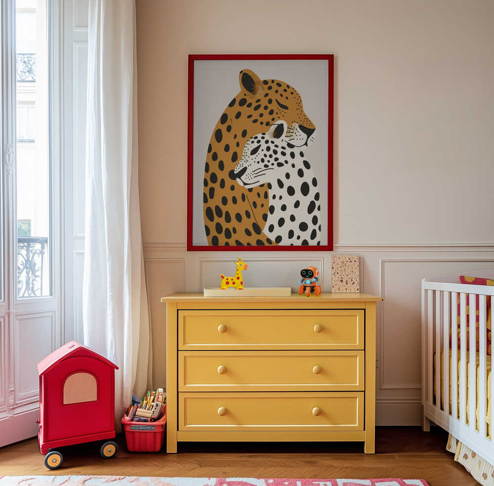Nursery artwork of two leopards with different patterns hanging on the wall above a yellow piece of furniture.