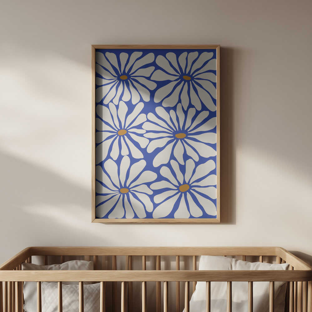Framed poster of big white flowers on a blue background hanging above the baby's crib