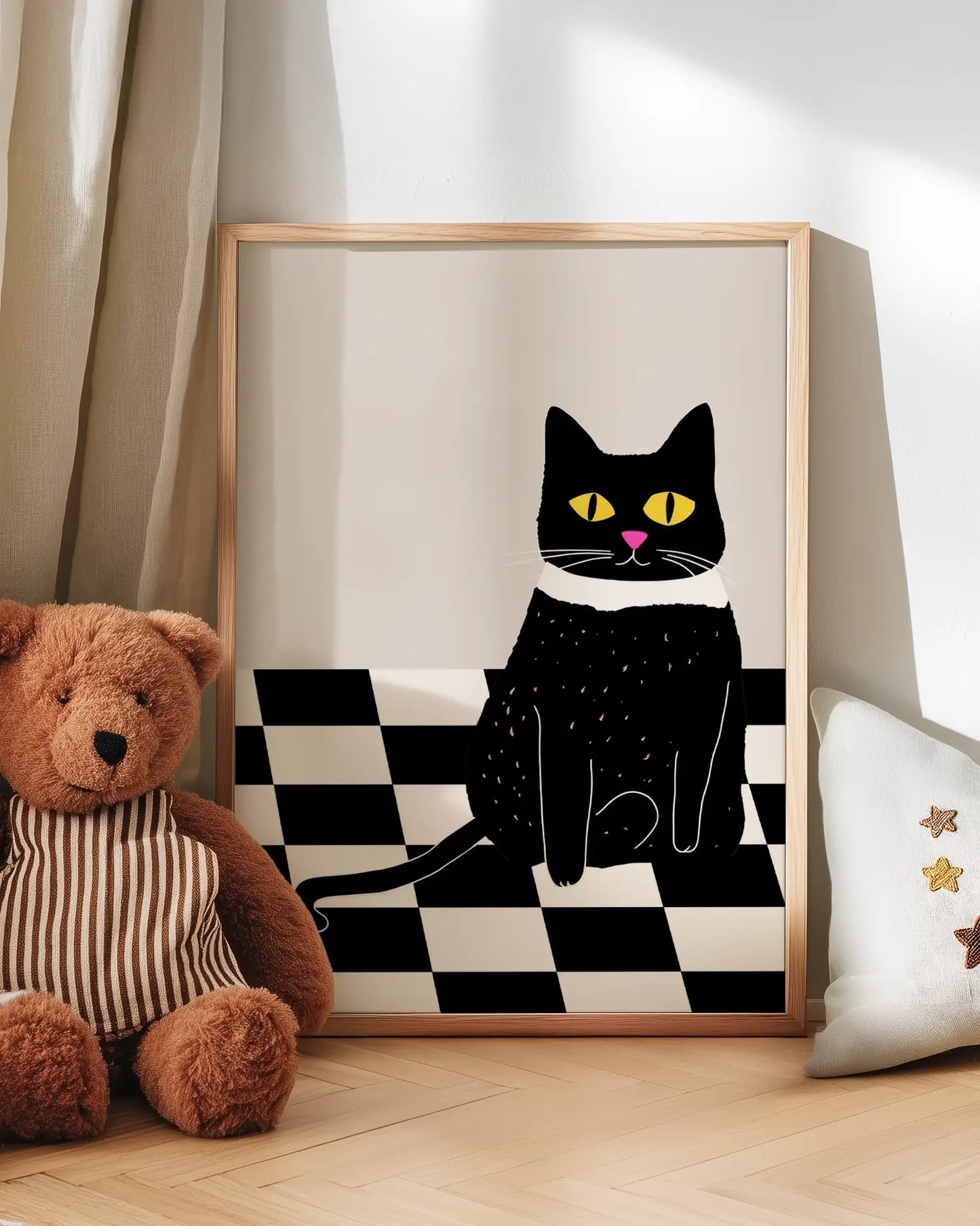 Artwork of a black cat on a checkered background next to a teddy bear and pillow.