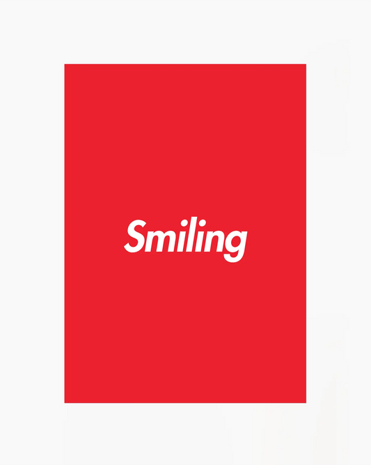 Red poster with 'Smiling' written in white