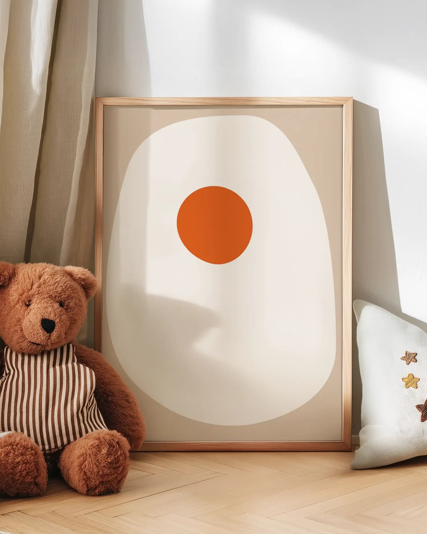 Artwork with a fried egg next to a teddy bear on a wooden floor. 