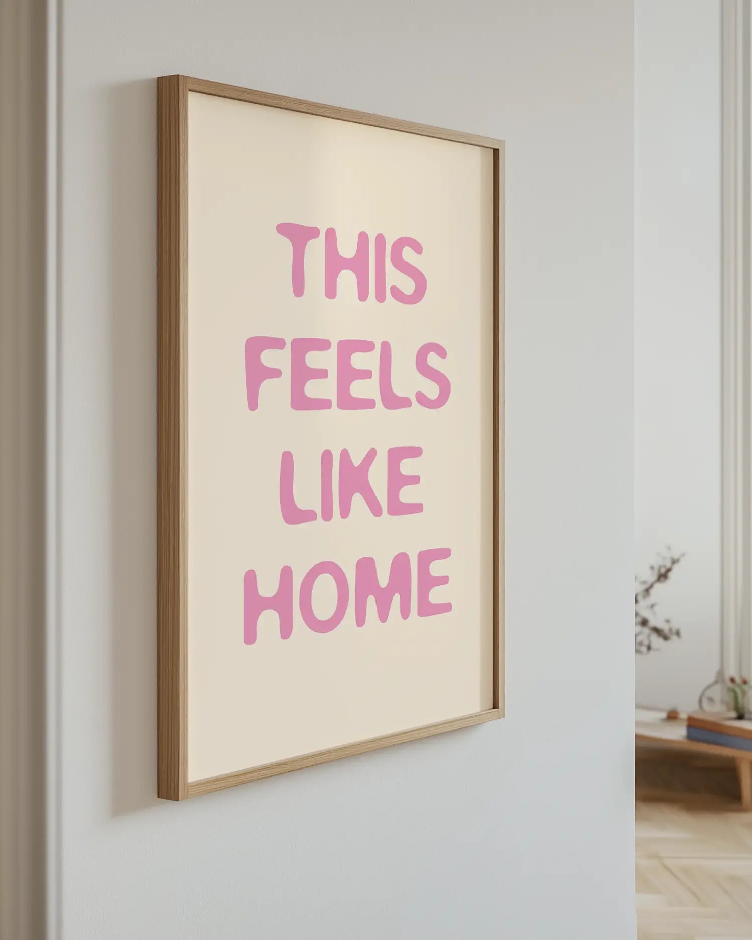 Artwork with 'This Feels Like Home' text in pink on a light background
