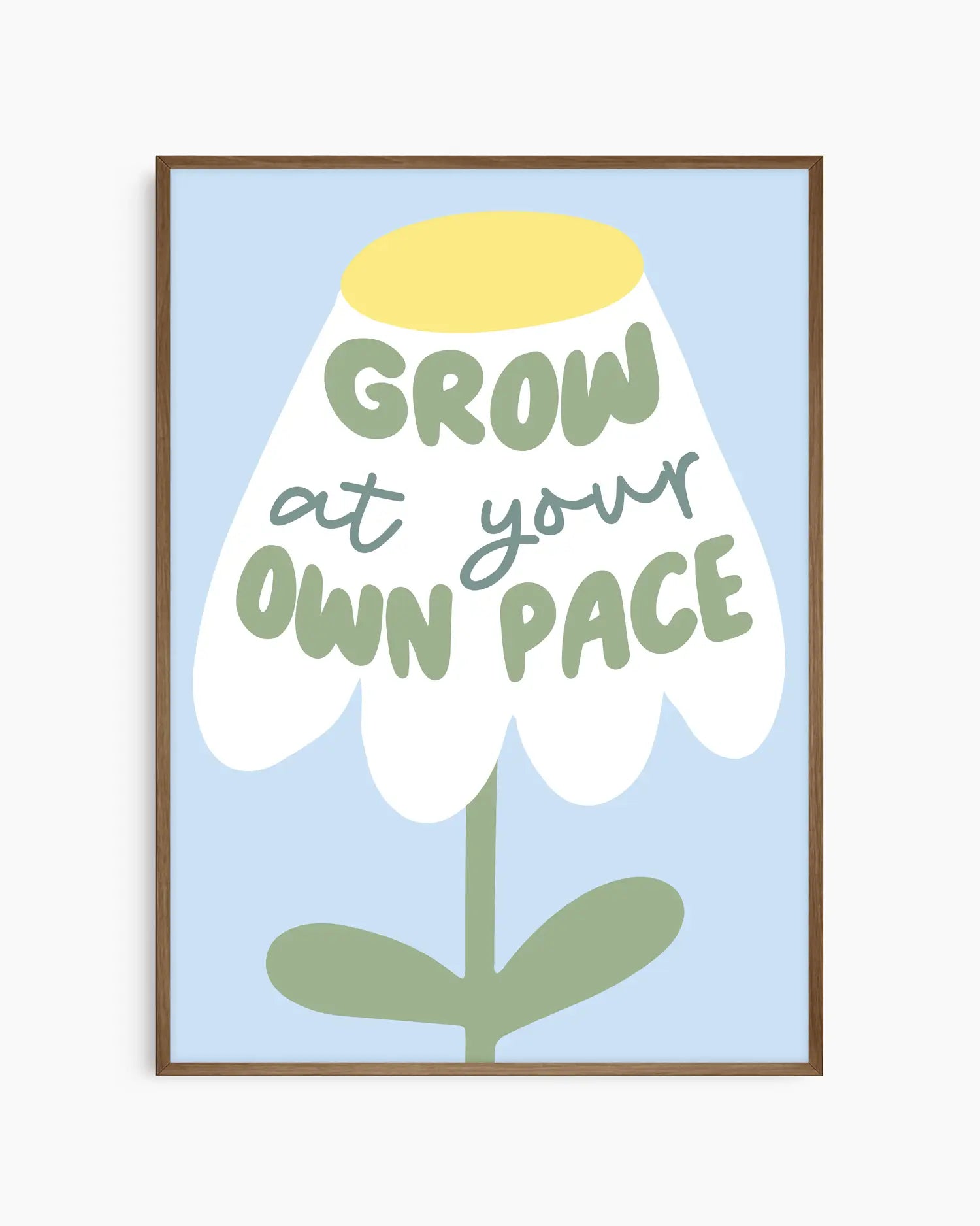 Framed artwork with a flower illustration and text 'Grow at your own pace' on a light blue background.