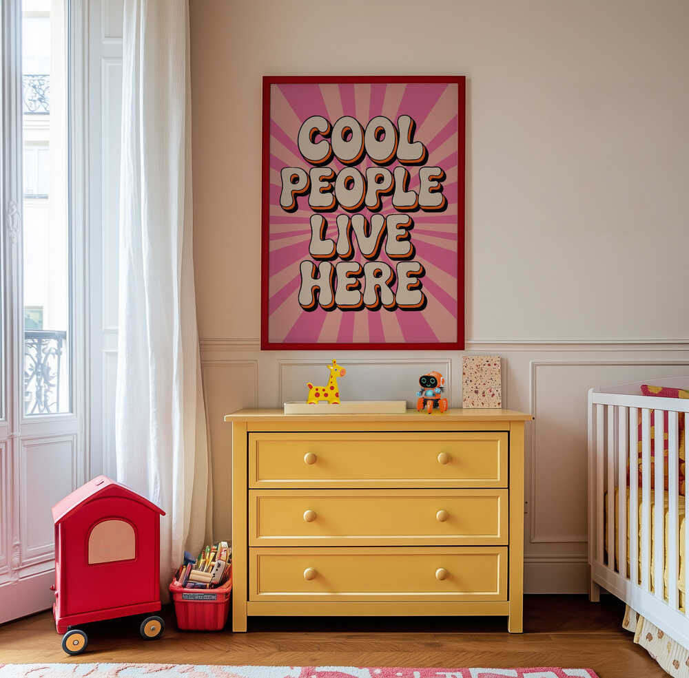 Pink poster in 70's style with the text 'Cool people live here' written on it hanging on the wall in the kids room. 