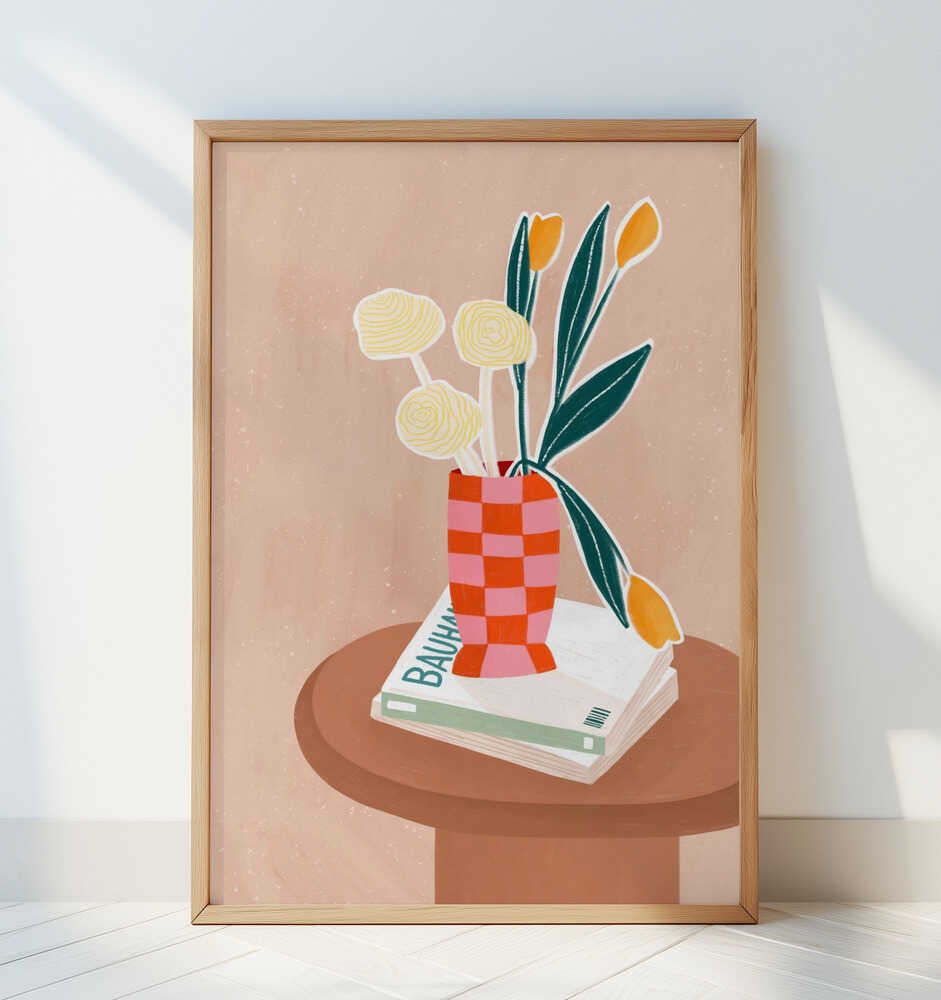 Framed beige children's poster with a brown side table with books on top and a pink and orange checkered vase with yellow flowers inside